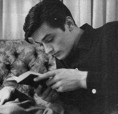 a man sitting on a couch reading a book