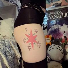 a woman's thigh with stars on it and a book in the back ground