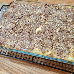 a casserole dish with meat and cheese on it sitting on a cooling rack