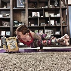 a woman is doing push ups on a yoga mat in front of a bookshelf