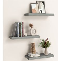 two shelves with books, vases and pictures on them