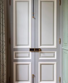 an open white door with gold handles in a room