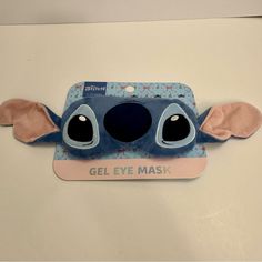 an eye mask with ears and eyes on top of a white surface, in the shape of a cartoon character