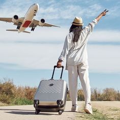 a man with a suitcase and an airplane in the background