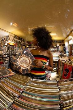 a woman is looking at records in a record store