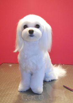 a white stuffed dog sitting on top of a table