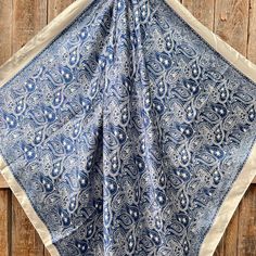 a blue and white bandana hanging on a wooden wall