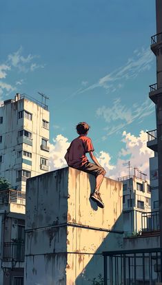 a man sitting on top of a cement wall with buildings in the backgroud