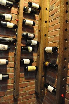 several wine bottles are lined up against a brick wall