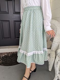 "Ladies small size skirt, made from a vintage Gunne Sax Pattern.  This is a perfect skirt to twirl in ! Plus it has pockets!  Pattern is Simplicity # 5491, from 1982.  Fits a 25\" waist.  Skirt length is 28\". Lying flat, skirt measures : Waist- 13\", Bottom of Ruffle 47\".  Fabric is cotton, green floral.   Has a ruffled edge with lace and  ribbon trim. bottom lace on ruffle is vintage.  Two side pockets, zipper, and a vintage button on waistband." Vintage Ruffled Skirt Petticoat, Vintage Long Gathered Skirt Bottoms, Vintage Long Gathered Skirt, Vintage Long Ruffled Petticoat, Vintage Long Skirt With Relaxed Fit, Vintage Tiered Petticoat With Lined Skirt, Vintage Ruffled Skirt For Spring, Vintage Spring Petticoat With Ruffled Skirt, Vintage Long Skirt Petticoat