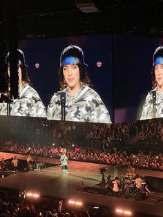 two people on stage in front of a large screen with images of women wearing headbands