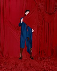 a man standing in front of a red curtain