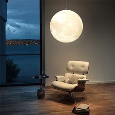 a white chair sitting in front of a window next to a book on the floor