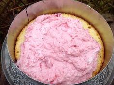 a cake with pink frosting in a metal pan