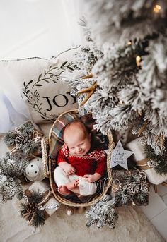 a baby in a basket surrounded by christmas decorations