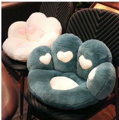 two chairs that have pillows on them in the shape of heart shaped animals, one is blue and the other has white hearts