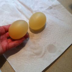 two eggs are being held in the palm of someone's hand on a napkin