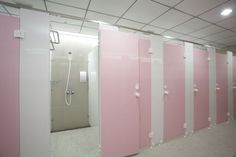 a row of pink stalls in a public restroom