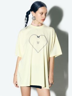 This clothing features a t-shirt with a short-sleeve design and a round neckline. The shirt features a large, heart-shaped graphic outlined with a chain-like design, centered on the chest area. Within the heart, there's a smaller heart with wings and the word CANDYFORNIA written inside it, suggesting a brand or theme. The contrast of the white graphic on the fabric creates a bold, graphic look.- The heart with wings motif gives the shirt a playful and youthful feel.- The chain outline of the heart adds a touch of edginess to the otherwise simple t-shirt.- The overall design is trendy and would likely appeal to a fashion-forward demographic looking for statement casual wear. Spring Streetwear T-shirt With Heart Graphic, Oversized Heart Graphic Top For Streetwear, Oversized Tops With Heart Graphic For Streetwear, Oversized Heart Graphic T-shirt For Streetwear, Oversized Heart Graphic T-shirt With Crew Neck, Oversized Heart Graphic Crew Neck T-shirt, Oversized Crew Neck T-shirt With Heart Graphic, Heart Graphic T-shirt For Spring Streetwear, Spring Heart Graphic T-shirt For Streetwear