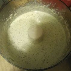 a blender filled with liquid sitting on top of a counter next to an apple