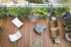 an overhead view of a wooden deck with chairs and potted plants