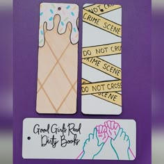 two bookmarks with handwritten words on them, one is holding a doughnut and the other has don't cross do not cross