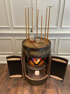 an old wooden barrel with candles and liquor bottles on it