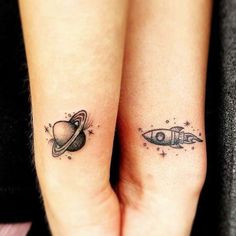 two small tattoos on the arms of people with saturn and earth in space behind them