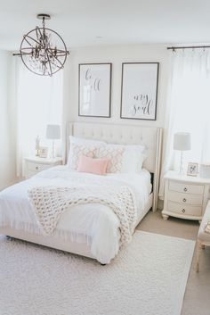 a white bed sitting in a bedroom next to two windows