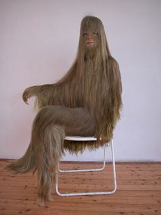 a woman sitting on a chair with long hair