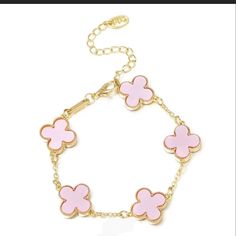 a pink and gold bracelet with four clovers on the link, hanging from a chain