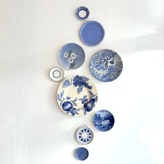 blue and white plates are hanging on the wall next to each other in an arrangement