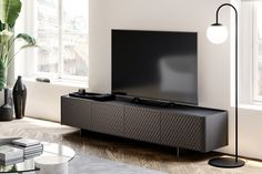 a flat screen tv sitting on top of a wooden entertainment center in a living room