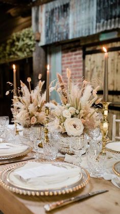 the table is set with white and gold place settings