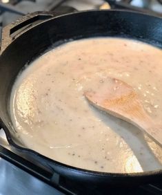 a wooden spoon is in a skillet on the stove