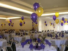 there are many balloons on the tables in this room with white tablecloths and chairs