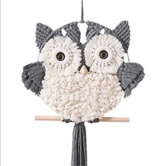 an owl ornament hanging from a wooden stick