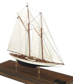 a model sailboat on a wooden stand