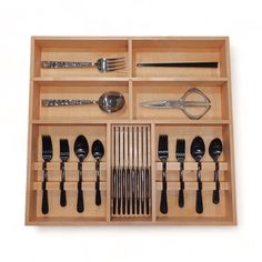 a wooden drawer with utensils and spoons in it