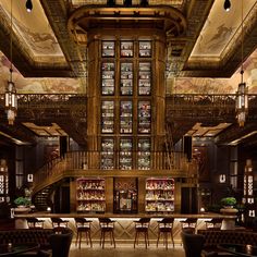 the interior of a restaurant with many tables and chairs in front of a bookcase