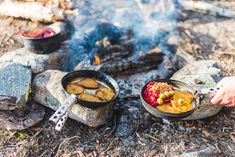 a person is cooking food over an open fire