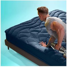 a man kneeling on top of a blue mattress