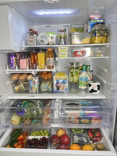 an open refrigerator filled with lots of different types of fruits and vegetables, including oranges