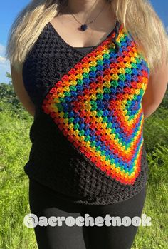 a woman is wearing a multicolored crocheted top