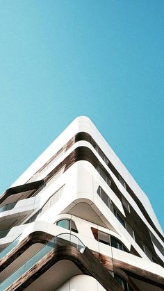 an airplane flying in the sky over a building with balconies on it's sides