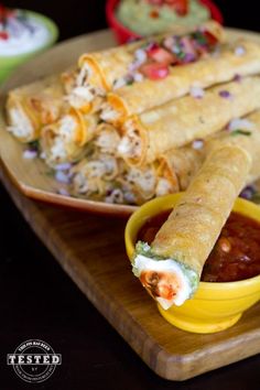 some tacos and salsa on a wooden tray