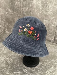 a blue hat with flowers embroidered on it