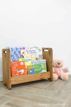 a teddy bear sitting next to a wooden book rack