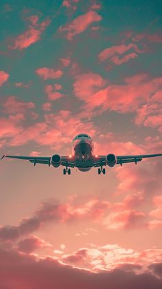 an airplane is flying in the sky with pink and blue clouds behind it at sunset