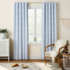 a living room with a white rug and blue curtains